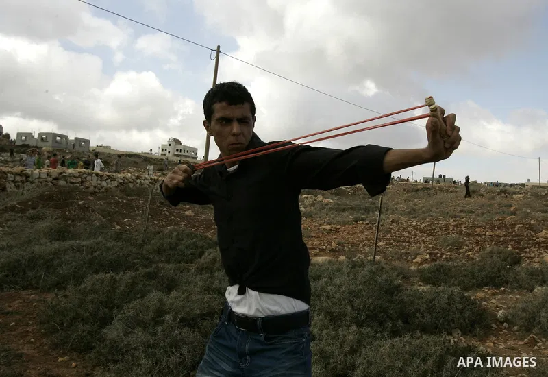 A Palestinian youth throws stones toward Israeli troops during clashes in the West Bank village of Qusra, south of Nablus, on September 23, 2011. A Palestinian man was shot dead by Israeli troops in clashes which erupted...