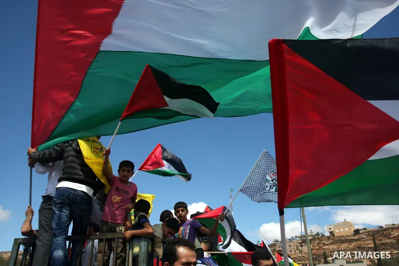Palestinians wave flags during the funeral of Issam Badran at Qusra village near the West Bank City of Nablus on Sept. 24, 2011. Issam Badran was allegedly shot dead and another seven were wounded by Israeli troops on 23...