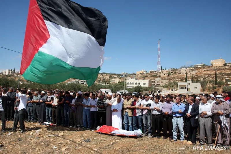 Palestinians pray next to the body of Issam Badran during his funeral in the West Bank village of Qusra near Nablus on Sept. 24, 2011. Israeli security forces shot dead Badran in the West Bank on Friday during a confront...