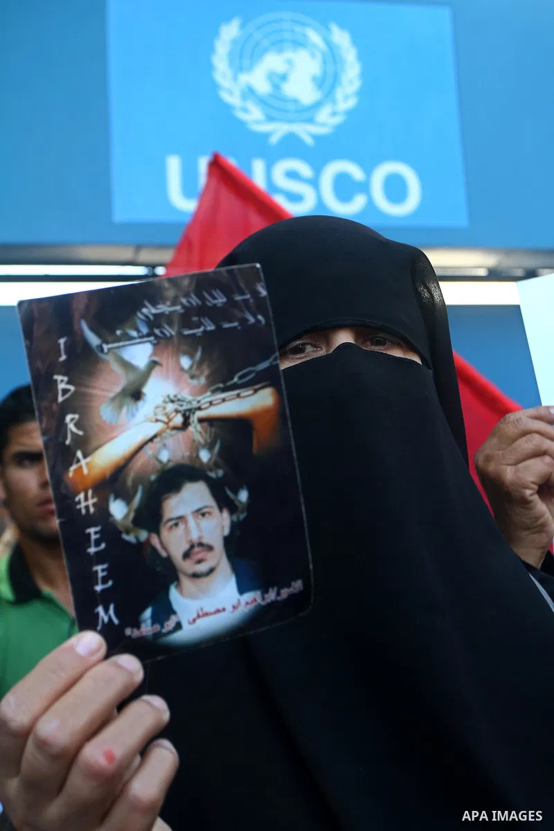 A Palestinian woman holds a picture of her prisoned relative in Israeli jails infront of the UNSCO headquarters in Gaza City on Sep. 26, 2011. About 7000 prisoners are in Israeli jails according to the Palestinian prison...