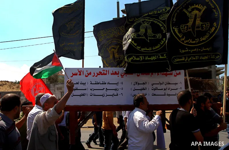 Palestinians hold flags and banners calling for the release of their prisoned relatives in Israeli jails, in Gaza City on Sep. 26, 2011. About 7000 prisoners are in Israeli jails according to the Palestinian prisoners mi...