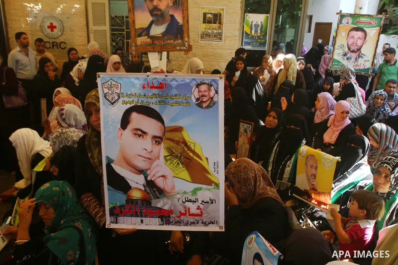 Palestinians hold pictures of their prisoned relatives in Israeli jails as they gather in a weekly activity calling for their liberty at the Red Cross headquarters in Gaza City on Sep. 26, 2011. About 7000 prisoners are...