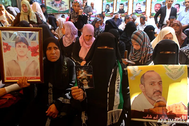 Palestinian women hold pictures of their prisoned relatives in Israeli jails as they gather in a weekly activity calling for their liberty at the Red Cross headquarters in Gaza City on Sep. 26, 2011. About 7000 prisoners...