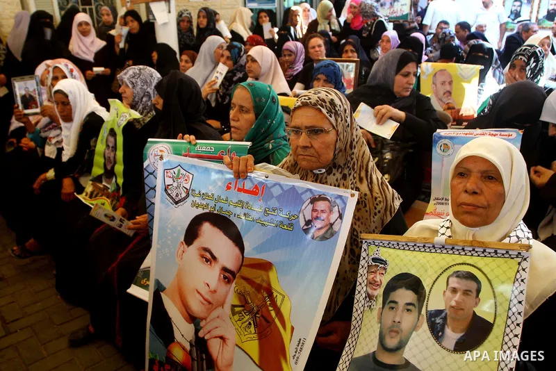 Palestinian women hold pictures of their prisoned relatives in Israeli jails as they gather in a weekly activity calling for their liberty at the Red Cross headquarters in Gaza City on Sep. 26, 2011. About 7000 prisoners...