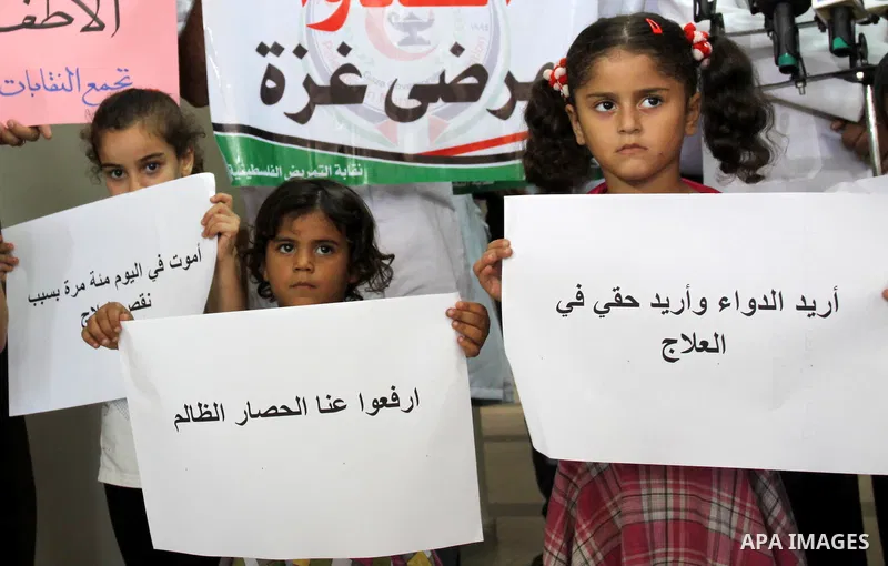 Palestinian doctors of Syndicate of Medical Professions and children hold posters during a protest at Abdel Aziz al-Rantisi hospital in Gaza city on Sep. 28, 2011. This protest organised against the lack of medicine.. Ph...