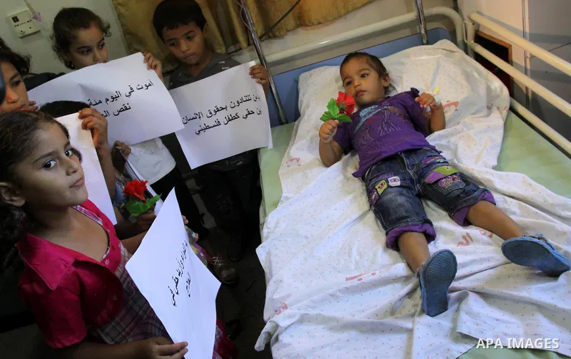 Palestinian doctors of Syndicate of Medical Professions and children hold posters during a protest at Abdel Aziz al-Rantisi hospital in Gaza city on Sep. 28, 2011. This protest organised against the lack of medicine.. Ph...