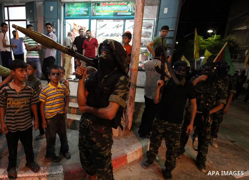 Palestinian militants of the Nabil Massud Unit of the Al-Aqsa Martyrs Brigades, an armed offshoot of the Fatah movement, march while the boys watch them, in the Jabalia refugee camp in the northern Gaza Strip on Sept. 28...
