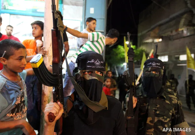 Palestinian militants of the Nabil Massud Unit of the Al-Aqsa Martyrs Brigades, an armed offshoot of the Fatah movement, march while the boys watch them, in the Jabalia refugee camp in the northern Gaza Strip on Sept. 28...