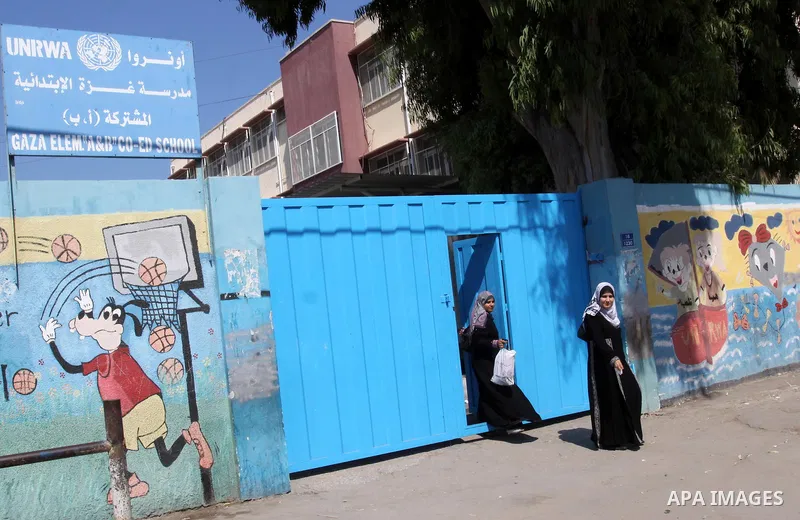 Palestinian women walk in front of United Nations Relief and Works Agency (UNRWA) closed school, in Gaza City on Sept. 29, 2011, against the decision made to suspend Staff Union President, Suhail al-Hindi. Some 16 thousa...