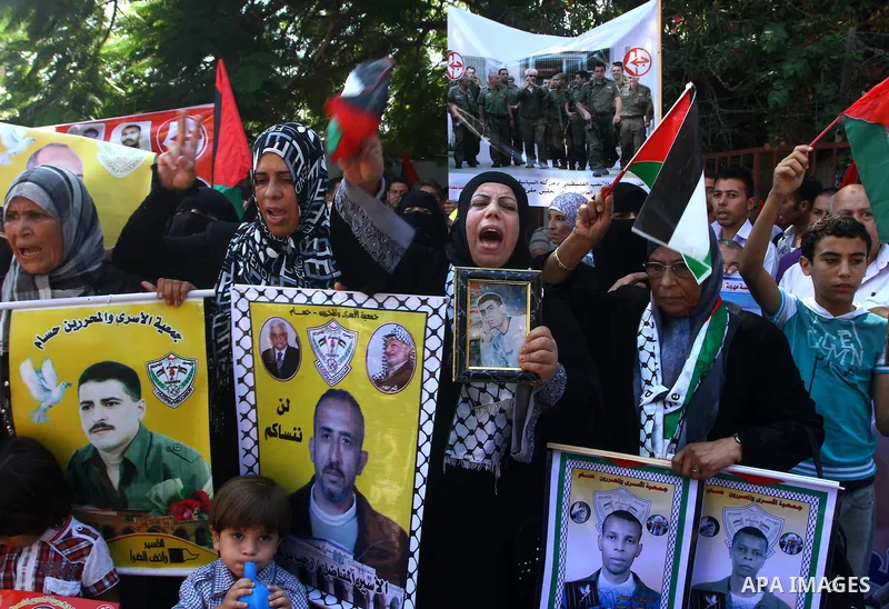 Palestinians shout slogans while holding pictures of their jailed relatives during a protest calling for their release from Israeli prisons outside the International Committee of the Red Cross (ICRC) in Gaza City on Sept...