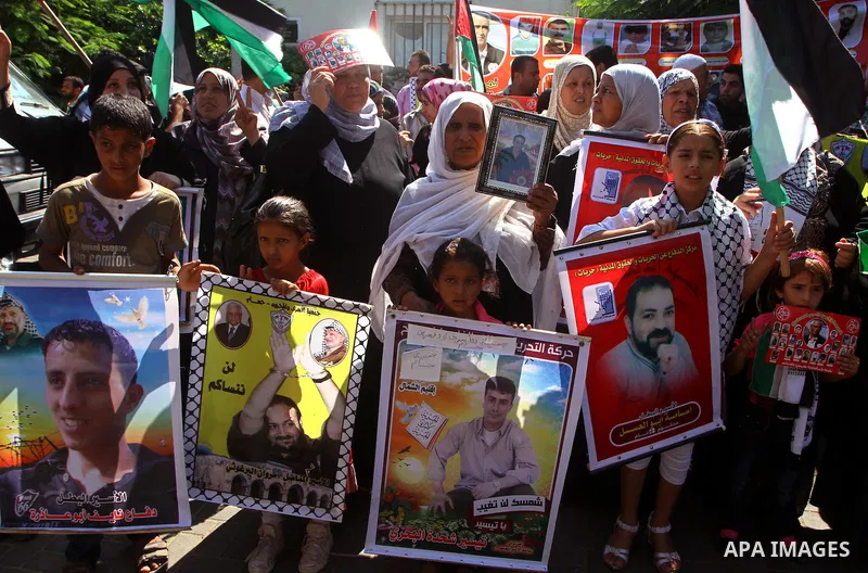 Palestinians hold pictures of their jailed relatives during a protest calling for their release from Israeli prisons outside the International Committee of the Red Cross (ICRC) in Gaza City on September 29, 2011. Photo b...
