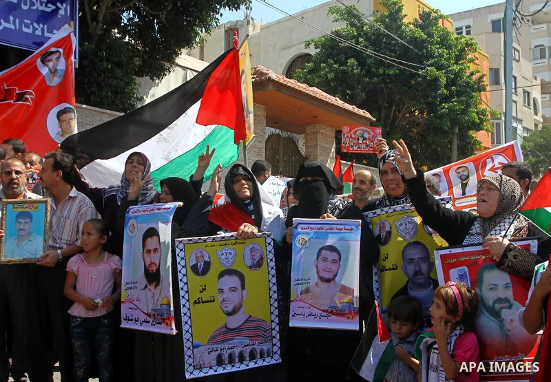 Palestinians shout slogans while holding pictures of their jailed relatives during a protest calling for their release from Israeli prisons outside the International Committee of the Red Cross (ICRC) in Gaza City on Sept...
