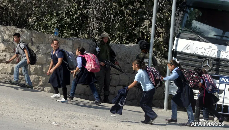 Palestinian schoolchildren walk past Israeli soldiers standing guard in the east Jerusalem neighborhood of Silwan, Thursday, Sept. 29, 2011. Israel on Tuesday approved construction of 1,100 homes for Jews on the annexed...