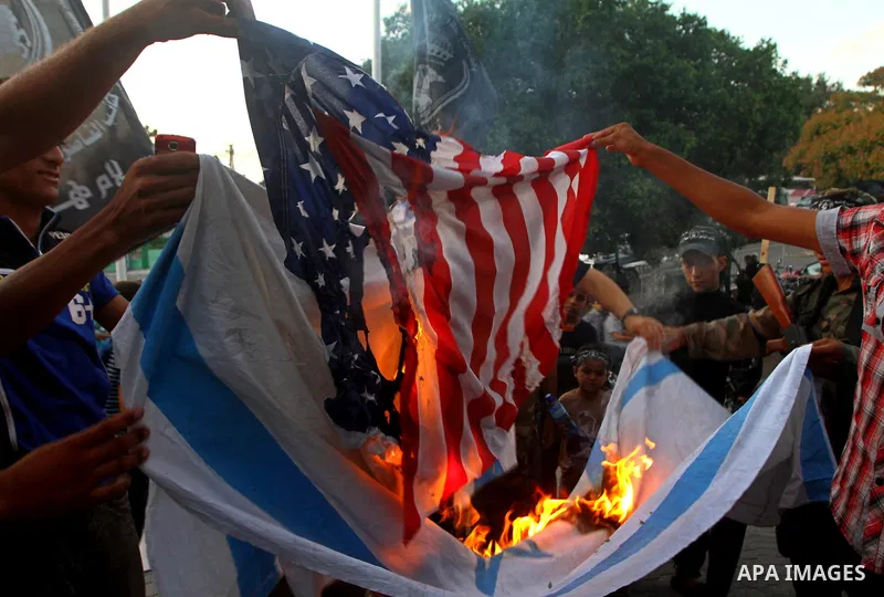 Palestinian militants of Popular Resistance Committees burn an Israeli and American flags during a rally to mark the 12th anniversary of Al-Aqsa Intifada (uprising) in Gaza city on Sept. 29,2011. Israel on Tuesday approv...