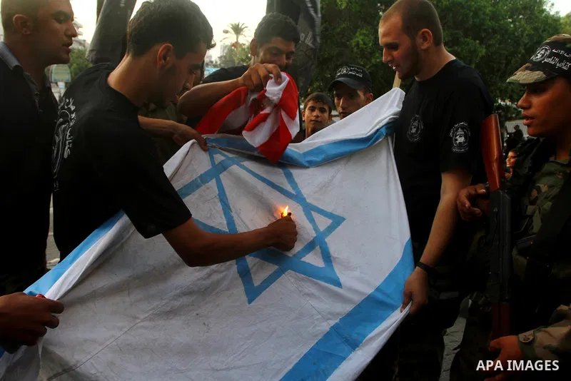 Palestinian militants of Popular Resistance Committees burn an Israeli and American flags during a rally to mark the 12th anniversary of Al-Aqsa Intifada (uprising) in Gaza city on Sept. 29,2011. Israel on Tuesday approv...