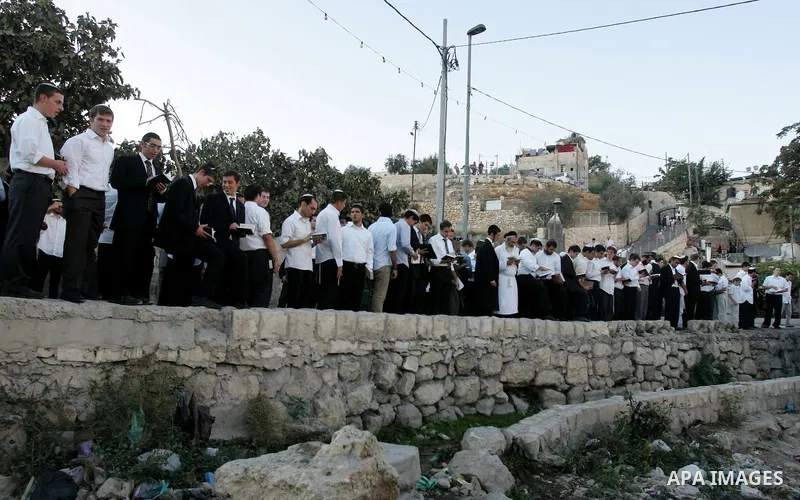 Jews gather to read prayers and perform 'Tashlich,' meaning to 'cast off,' near a small stream of water overlooking the arab East Jerusalem village of Silwan, at sun down on the first day of Jewish New Year, or Rosh Hash...