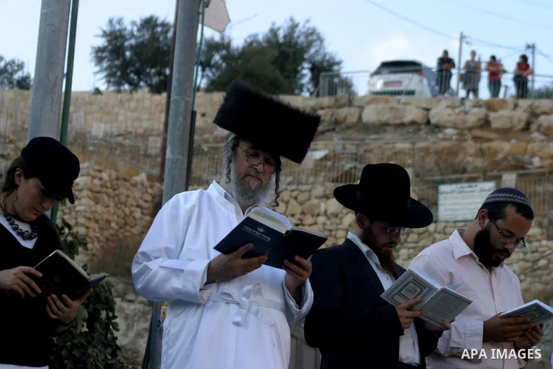 Jews gather to read prayers and perform 'Tashlich,' meaning to 'cast off,' near a small stream of water overlooking the arab East Jerusalem village of Silwan, at sun down on the first day of Jewish New Year, or Rosh Hash...