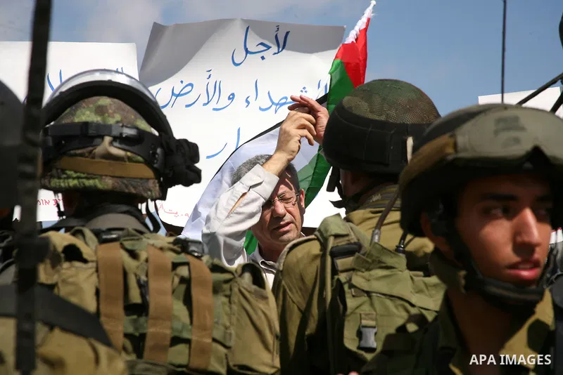 Israeli soldiers stand guard as Palestinian protestors demonstrate against the Israeli occupation in farm land close to the Palestinian village of Beit Omar near the Israeli settlement of Karmi Tsour, north the West Bank...