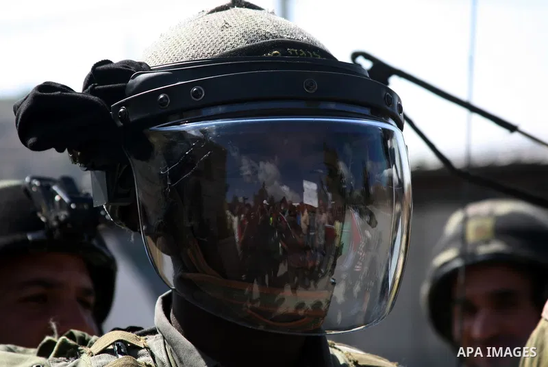 Israeli soldiers stand guard as Palestinian protestors demonstrate against the Israeli occupation in farm land close to the Palestinian village of Beit Omar near the Israeli settlement of Karmi Tsour, north the West Bank...