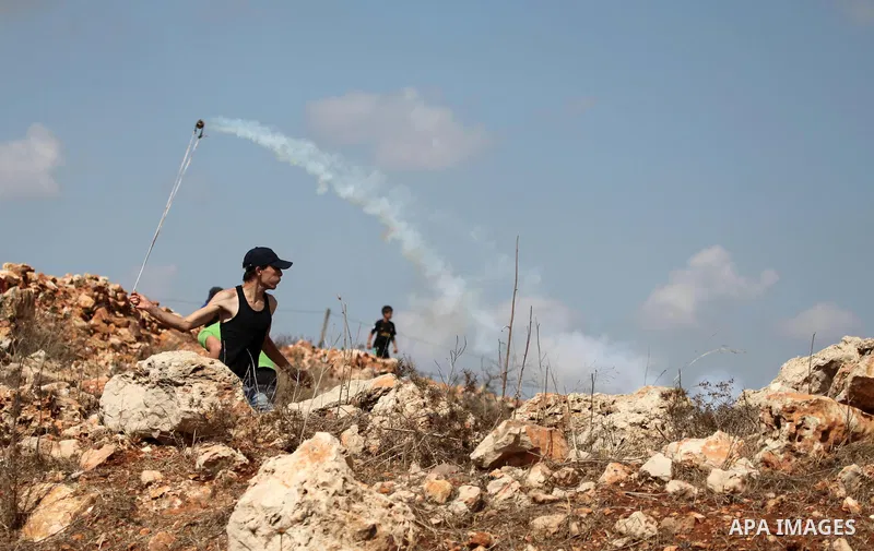 Palestinian youths clash with Israeli forces following a weekly demonstration against Israeli settlement expansion, in the West Bank village of Nabi Saleh, near the Jewish settlement of Halamish on September 30, 2011. Ph...