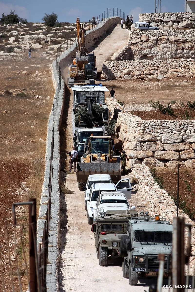 Israeli border police officers stand guard as demolition vehicles destroy a man-made reservoir on a Palestinian farm near the West Bank city of Hebron, on 04 October 2011. Reports state that tensions rose as Palestinian...