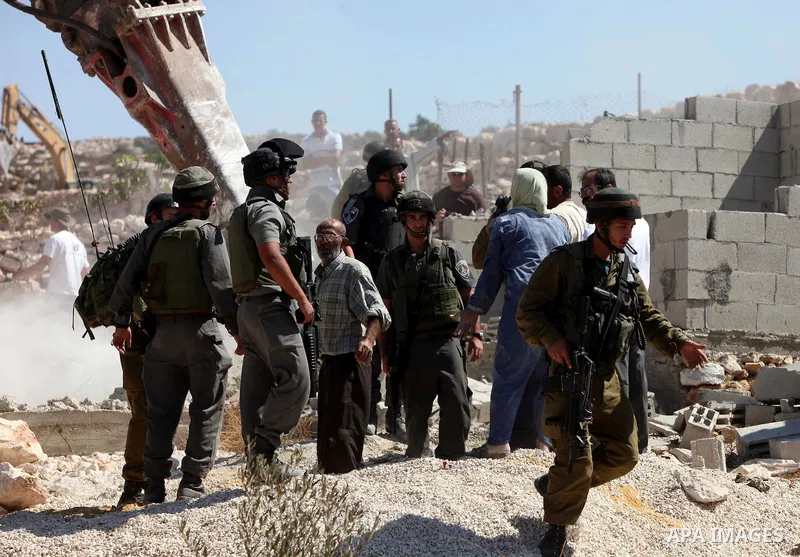 Israeli border police officers stand guard as demolition vehicles destroy a man-made reservoir on a Palestinian farm near the West Bank city of Hebron, on 04 October 2011. Reports state that tensions rose as Palestinian...