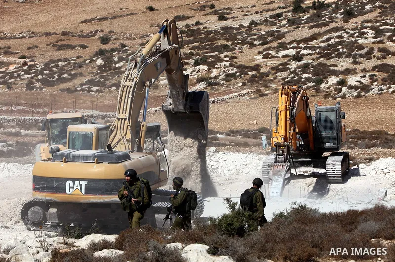 Israeli border police officers stand guard as demolition vehicles destroy a man-made reservoir on a Palestinian farm near the West Bank city of Hebron, on 04 October 2011. Reports state that tensions rose as Palestinian...