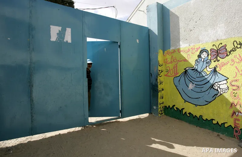 A Palestinian man stands on UNRWA school door because of a strike of teachers at a school in Rafah, southern Gaza Strip on October 5, 2011. Disrupted the study Wednesday in all schools and UN Relief and Works Agency for...