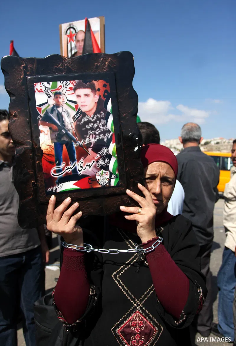 Palestinian protestors take part a demonstration calling for the release of prisoners held in Israeli jails and in support of inmates in hunger strike, on October 5, 2011 near Israel's Ofer prison, between Jerusalem and...
