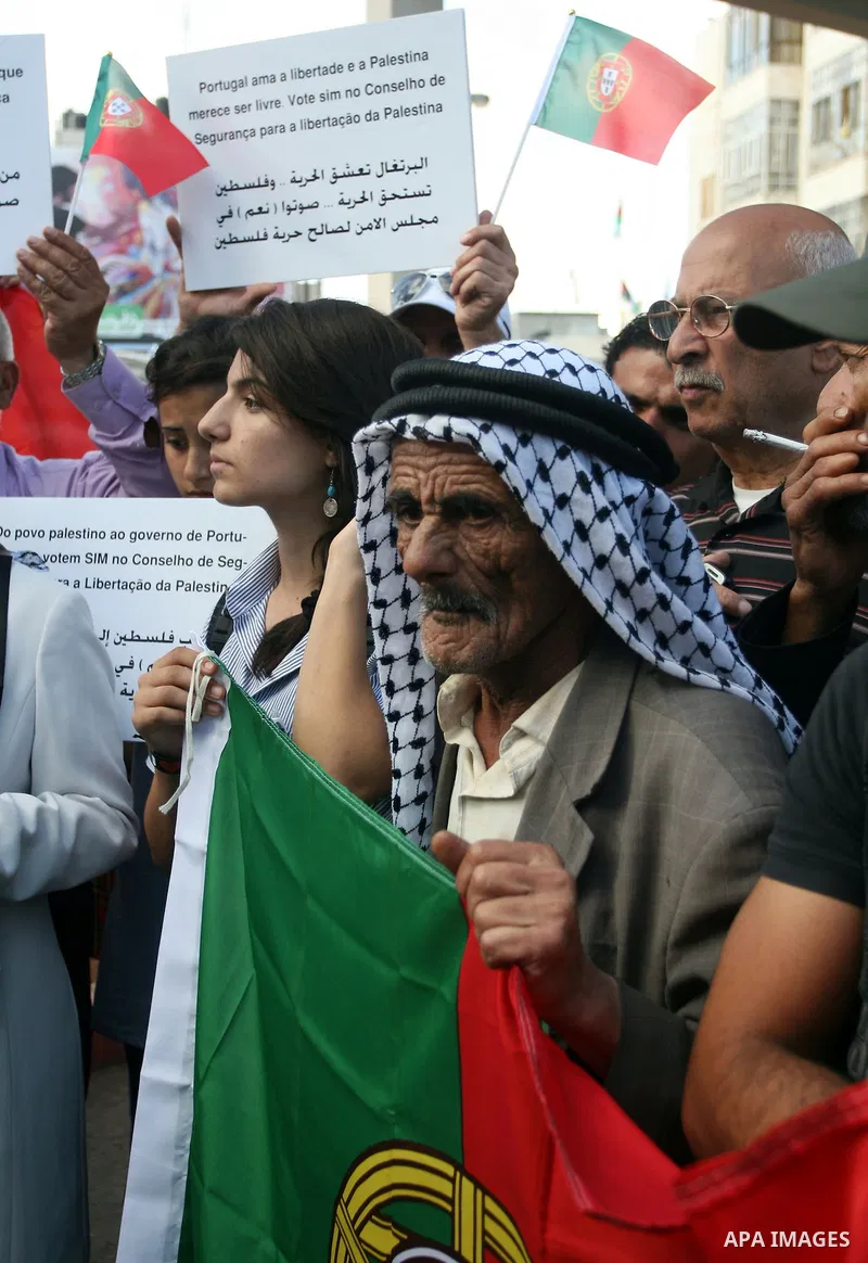 Palestinians wave their national flag and Portugal flag as they celebrate the National Day of Portugal in the West Bank city of Ramallah October 6, 2011. Palestinians have demanded the State of Portugal to vote for the r...