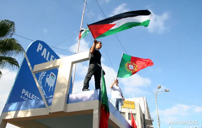 Palestinians wave their national flag and Portugal flag as they celebrate the National Day of Portugal in the West Bank city of Ramallah October 6, 2011. Palestinians have demanded the State of Portugal to vote for the r...