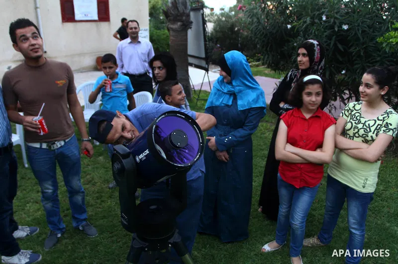 Palestinians look at the moon through a small telescope brought into Gaza City by the French Cultural Center (CCF) on Oct, 6, 2011. The CCF gave Gazan children and youths the opportunity to look at the stars and planets...