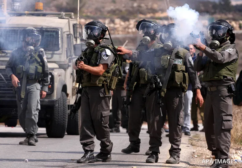 Israeli soldiers fire tear gas canister to disperse Palestinian stone throwers during clashes following a weekly demonstration against Israeli settlement expansion, in the West Bank village of Nabi Saleh, on October 7, 2...
