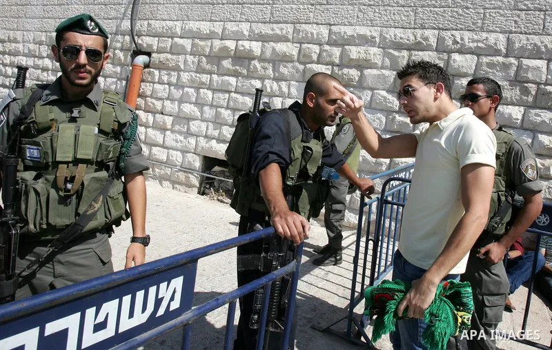 Israeli soldiers stand guard as Palestinian Muslims attend Friday prayers at a street in the neighbourhood of Ras al-Amud, in East Jerusalem (Al-Aqsa Mosque compound in the background) on October 7,2011. Israel limited a...