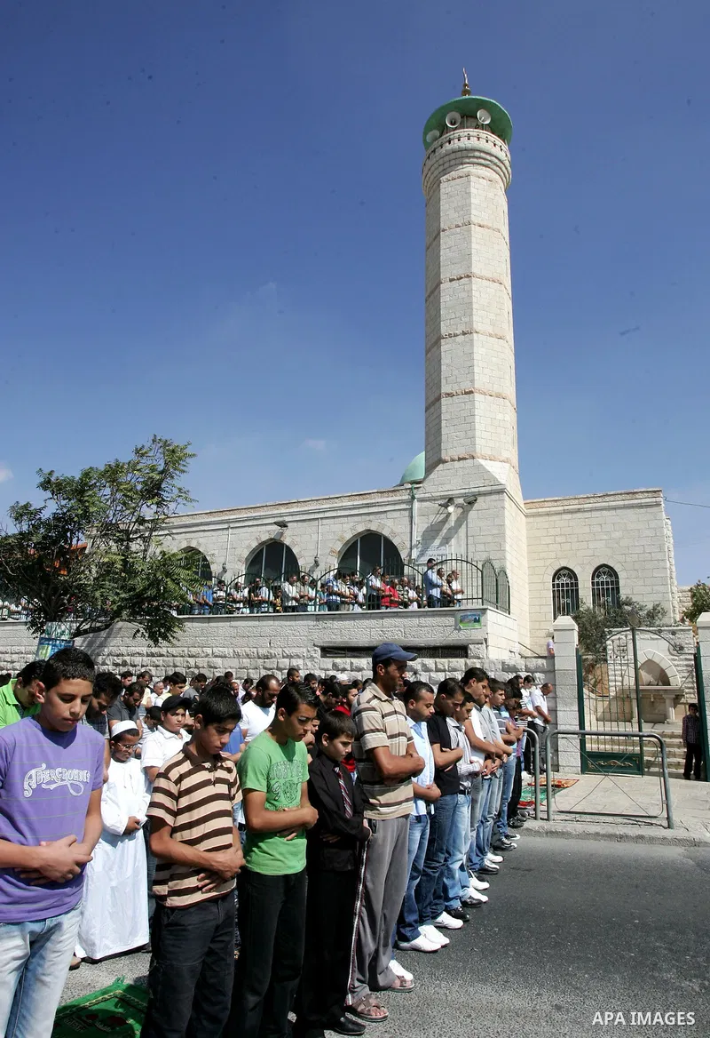 Palestinian Muslims attend Friday prayers at a street in the neighbourhood of Ras al-Amud, in East Jerusalem (Al-Aqsa Mosque compound in the background) on October 7,2011. Israel limited access to Jerusalem's Al-Aqsa mos...