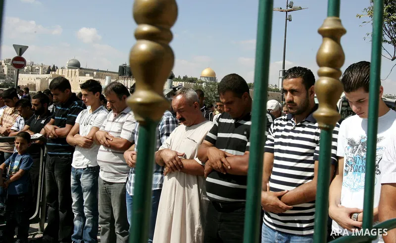 Palestinian Muslims attend Friday prayers at a street in the neighbourhood of Ras al-Amud, in East Jerusalem (Al-Aqsa Mosque compound in the background) on October 7,2011. Israel limited access to Jerusalem's Al-Aqsa mos...