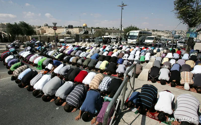 Palestinian Muslims attend Friday prayers at a street in the neighbourhood of Ras al-Amud, in East Jerusalem (Al-Aqsa Mosque compound in the background) on October 7,2011. Israel limited access to Jerusalem's Al-Aqsa mos...
