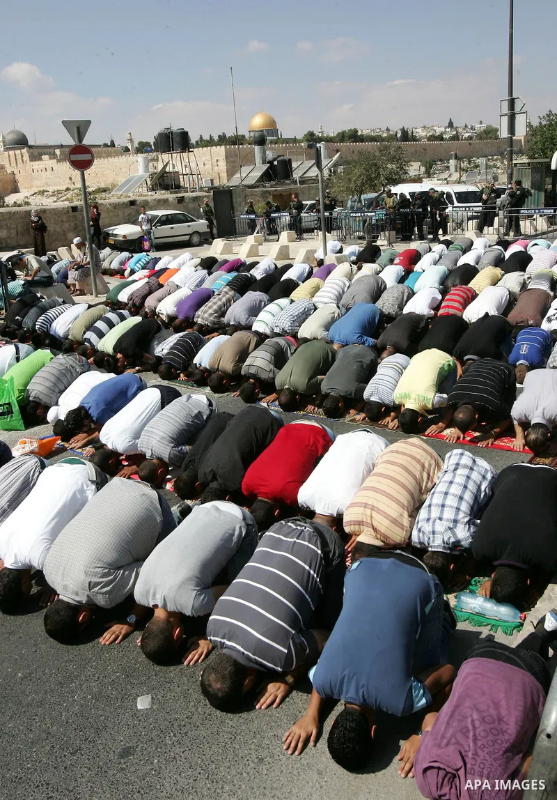 Palestinian Muslims attend Friday prayers at a street in the neighbourhood of Ras al-Amud, in East Jerusalem (Al-Aqsa Mosque compound in the background) on October 7,2011. Israel limited access to Jerusalem's Al-Aqsa mos...