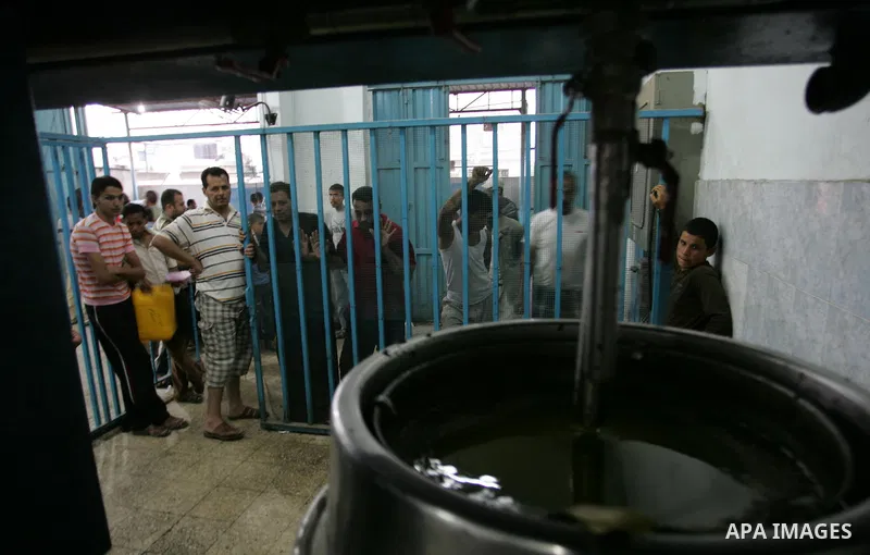 Palestinian men work in an olive oil factory during the olive harvest season , in Khan Yunis in the southern Gaza Strip on October 8, 2011. Palestinians began the annual harvest of olives, a staple for many local farmers...