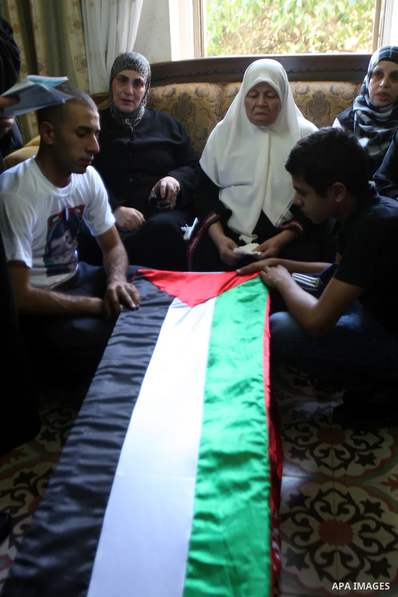 Relatives of Hafez Abu Zant stands over the coffin containing his remains in the West Bank city of Nablus 9 October 2011. Israeli authorities on Sunday afternoon transferred the remains of a Palestinian fighter killed in...