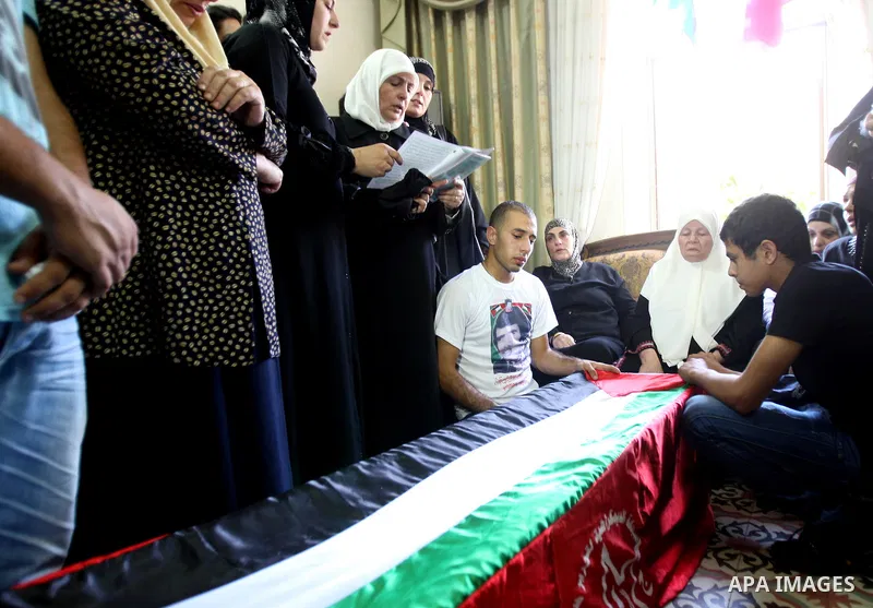 Relatives of Hafez Abu Zant stands over the coffin containing his remains in the West Bank city of Nablus 9 October 2011. Israeli authorities on Sunday afternoon transferred the remains of a Palestinian fighter killed in...