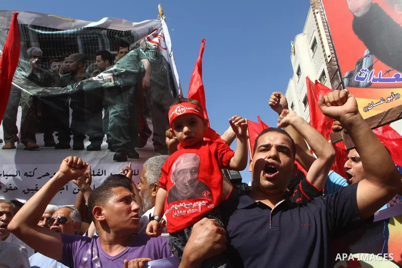 Palestinians take part in a protest in solidarity with Palestinian prisoners held in Israeli jails, in front of the International Red Cross building in Gaza City, Monday, Oct. 10, 2011. Gaza's Hamas rulers have imposed n...