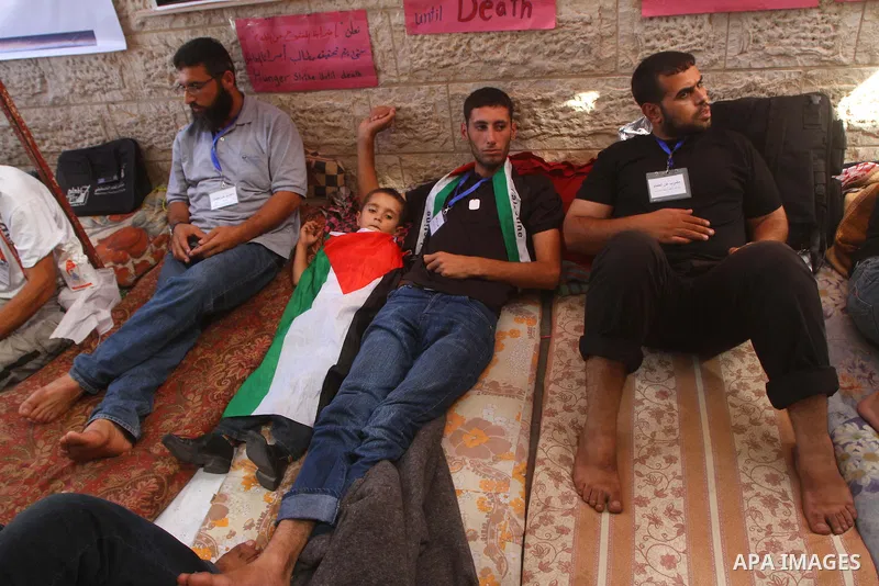 Palestinians take part in a protest in solidarity with Palestinian prisoners held in Israeli jails, in front of the International Red Cross building in Gaza City, Monday, Oct. 10, 2011. Gaza's Hamas rulers have imposed n...
