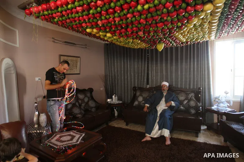 A man from the ancient Samaritan community decorates a Sukkah made from fresh fruit for the holiday of the Tabernacles, or Sukkot, in Mount Gerizim near the West Bank town of Nablus, Monday, Oct. 10, 2011. The Sukkah is...