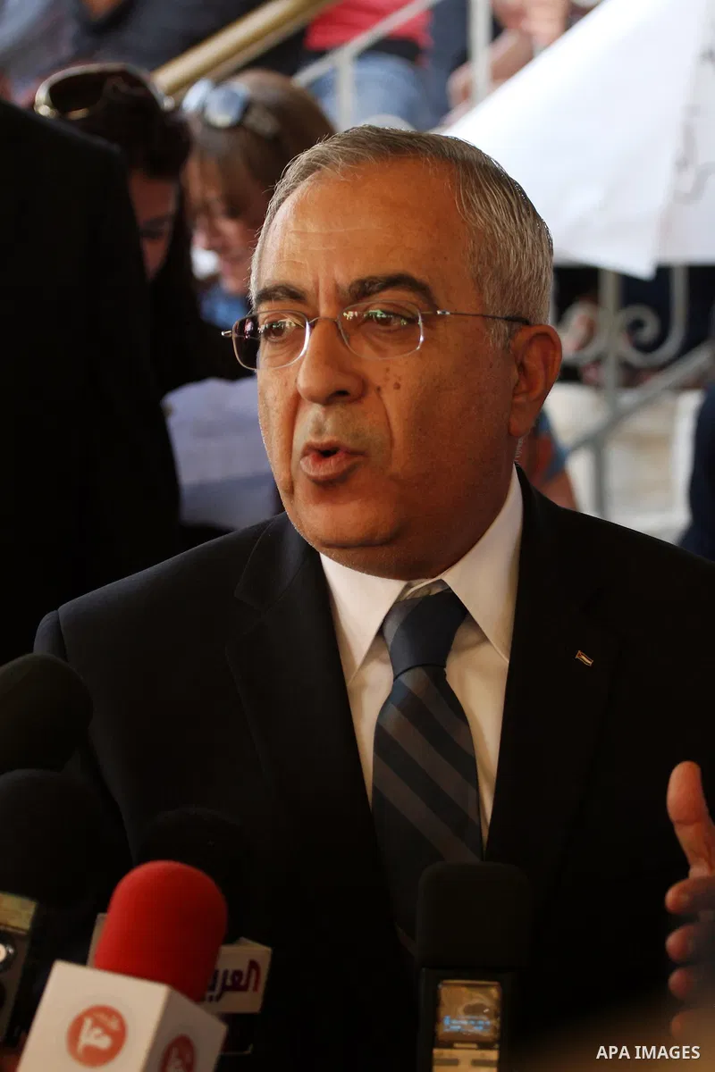 Palestinian prime minister Salam Fayyad sits with relatives of Palestinian prisoners who are held in Israeli jails in a protest tent build in front of the Red Cross' offices in the West Bank city of Ramallah, on October...