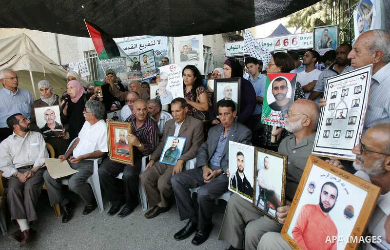 Palestinians take part in a protest in solidarity with their relatives Palestinian prisoners held in Israeli jails in a protest tent in front of the Red Cross' offices in east Jerusalem, on October 10, 2011. Thousands of...