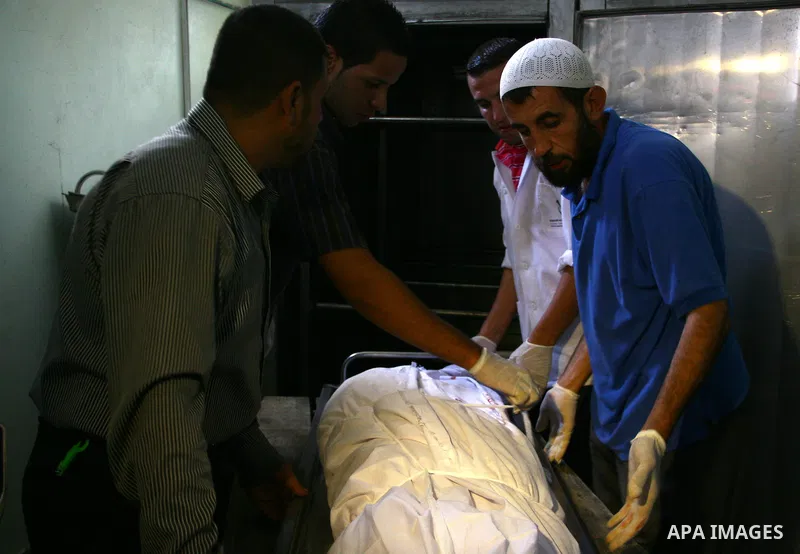 Palestinians gather around the body of Ahmed Azazmeh, killed in an explosion, during his funeral in Beit Hanoun, near the Erez Crossing between Gaza Strip and Israel, Monday, Oct. 10, 2011. Palestinian officials in the G...