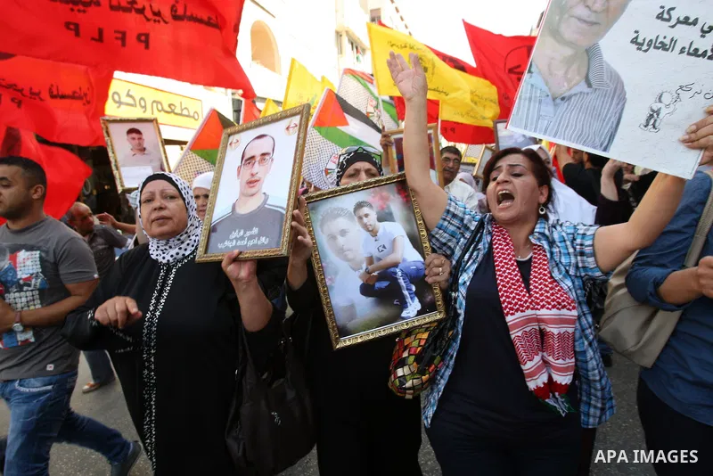 Palestinians participate in a demonstration in solidarity with prisoners jailed in Israel, in the West Bank city of Nablus, Oct. 11, 2011. According to the Israeli Prison Service spokesman, over 200 Palestinian prisoners...