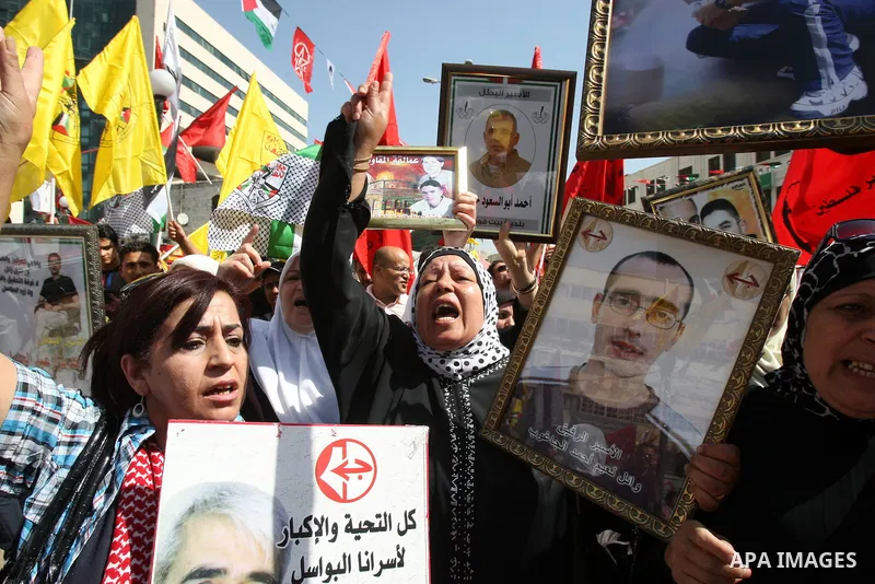 Palestinians participate in a demonstration in solidarity with prisoners jailed in Israel, in the West Bank city of Nablus, Oct. 11, 2011. According to the Israeli Prison Service spokesman, over 200 Palestinian prisoners...