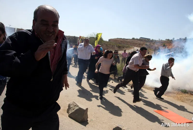 Palestinian protestors run for cover as Israeli forces fire tear gas canisters during clashes following a demonstration calling for the release of prisoners held in Israeli jails and in support of inmates in hunger strik...